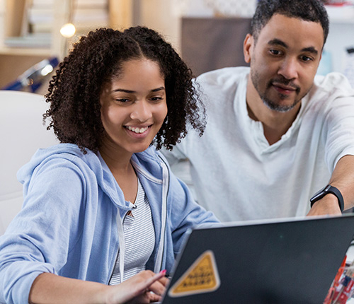 father and his daughter working with their laptop
